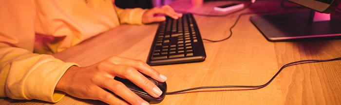 Persona con un portátil y teclado jugando online