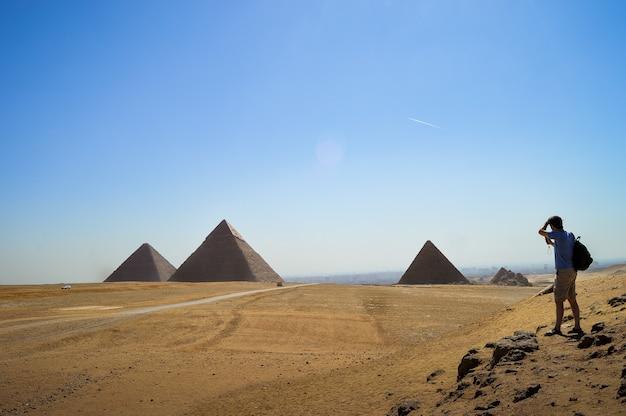 Foto gratuita primer plano de un hombre de pie y mirando la necrópolis de giza en egipto