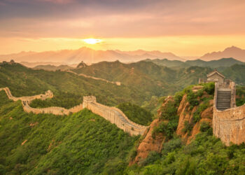 Gran Muralla China con múltiples torres de vigilancia Ming serpenteando entre montañas Beijing al atardecer.