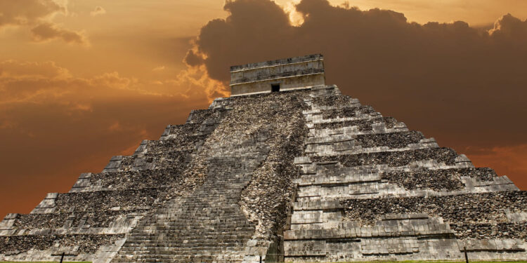 El Castillo de Chichén Itzá, pirámide maya de 24 metros de altura que muestra la fusión de estilos arquitectónicos maya y tolteca, con cielo dramático de atardecer en Yucatán, México