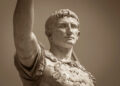 Busto de mármol del primer emperador romano Augusto con expresión seria y contemplativa, vistiendo armadura militar decorada, representando el poder centralizado del Imperio Romano