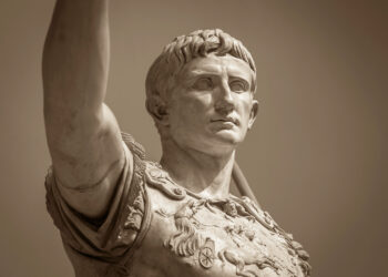 Busto de mármol del primer emperador romano Augusto con expresión seria y contemplativa, vistiendo armadura militar decorada, representando el poder centralizado del Imperio Romano