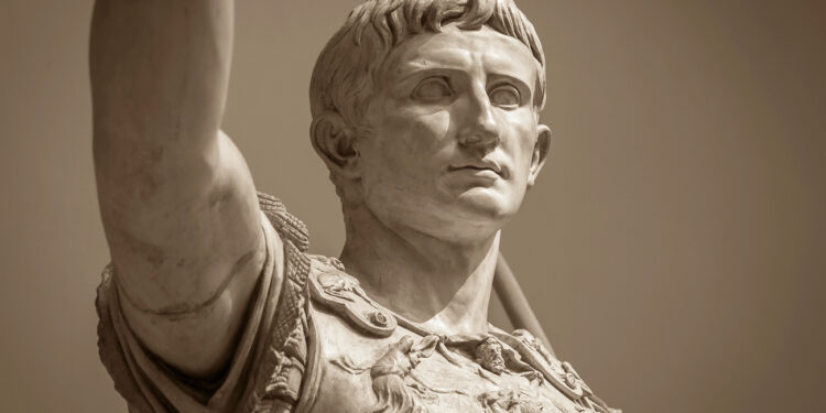 Busto de mármol del primer emperador romano Augusto con expresión seria y contemplativa, vistiendo armadura militar decorada, representando el poder centralizado del Imperio Romano