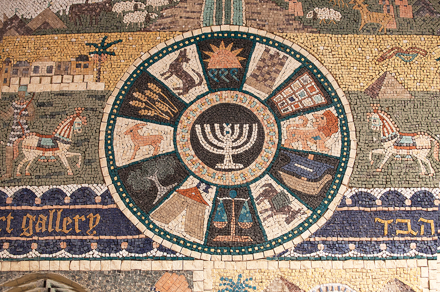 Mosaico antiguo que muestra las doce tribus de Israel con sus símbolos: Rubén (agua), Simeón (torre), Leví (pectoral), Judá (león), Isacar (asno), Zabulón (barco), José (trigo), Benjamín (lobo), Dan (balanza), Neftalí (cierva), Gad (campamento) y Aser (olivo), con menorá central.