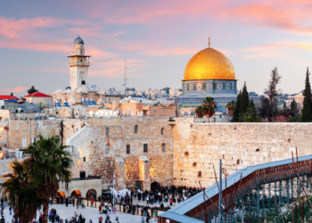 Vista de Jerusalén al atardecer con el Muro de las Lamentaciones en primer plano y el Domo de la Roca al fondo, los lugares más sagrados del judaísmo y el islam en la ciudad santa de las tres religiones abrahámicas