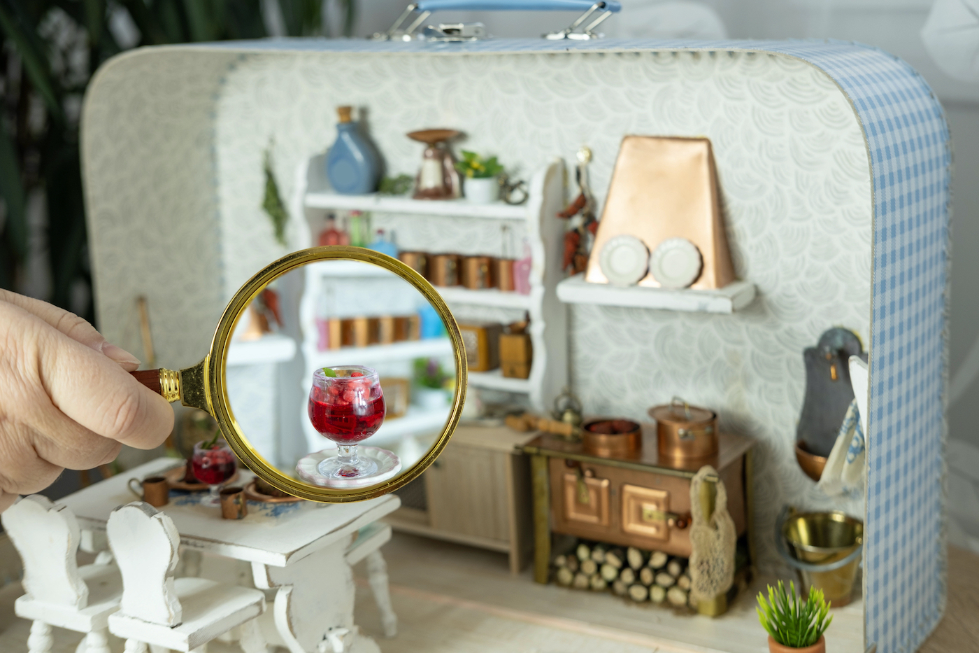 Baby house (poppenhuizen) holandesa del siglo XVII en miniatura, detalle de habitación doméstica con muebles a escala, decoración cerámica y lupa de aumento mostrando precisión microscópica.