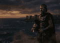 Menelao, rey de Esparta con armadura griega, mirando hacia Troya en el horizonte, sosteniendo casco, símbolo de la búsqueda de Helena