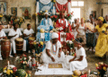 Ceremonia de santería cubana con santera realizando la tirada de dilogún, tambores batá, ofrendas de frutas, collares de orishas y altar sincrético con imágenes de santos católicos y atributos de los orishas
